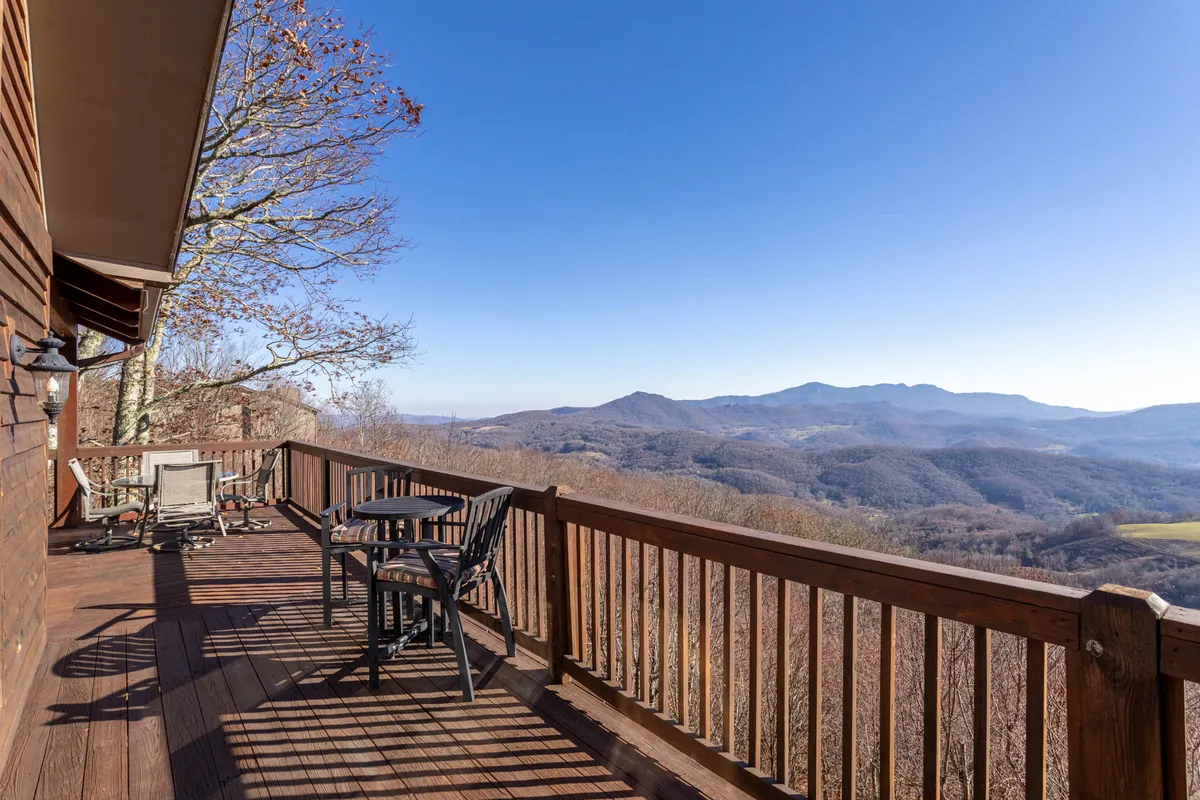 A spacious deck featuring comfortable seating, a sturdy railing, and expansive mountain vistas. The area is perfect for outdoor dining, stargazing, or simply taking in the beauty of the landscape with a loved one.